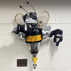 A bee made with pots and pans, tennis rackets, hockey pucks and various machine parts