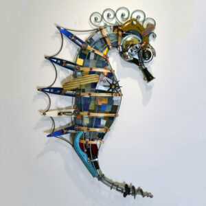 A seahorse constructed of cross country skis, a clarinet, formica chips, and various machine parts.