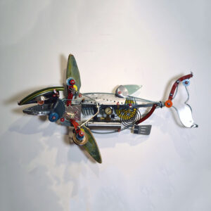 A fish made of ceramic fins, a plexiglass tail, kitchen utensils, a bicycle fender and various machine parts.