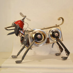 A dog constructed of an antique mail box, golf clubs, a bicycle seat, trowels, and various machine parts.